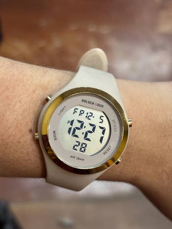 reviewer wearing the ticker  and showing the look   that has time  of week, date, time, and time  of period  info