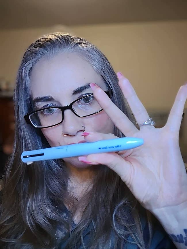 reviewer holding penpal pen with makeup done