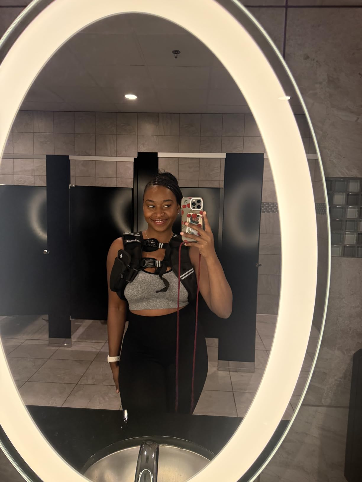 Person successful  gym attire with a telephone  strapped to their chest, taking a reflector  selfie successful  a restroom
