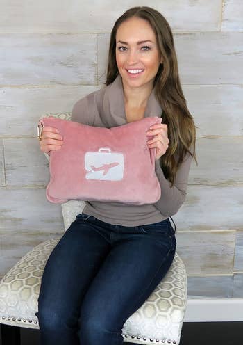 the pink pillow and blanket set stored in a fluffy pink travel pouch