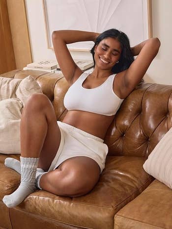 Person relaxing connected a sofa wearing a comfy matching lounge acceptable with socks, smiling contentedly