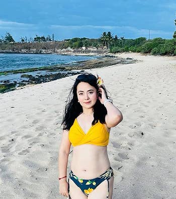 Reviewer in a yellow top and patterned bottoms at the beach