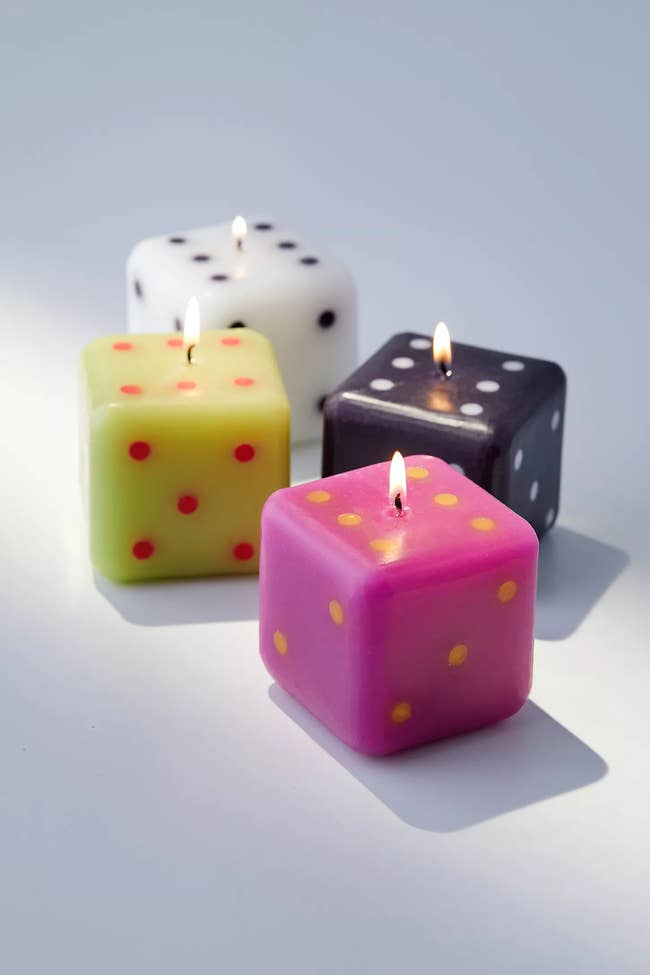 dice shaped candles in black, white, pink, and yellow