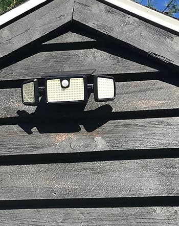 reviewer photo of one of the motion sensor lights mounted to the exterior of a house