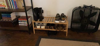 The bamboo two-tier shoe rack in a reviewer's entryway