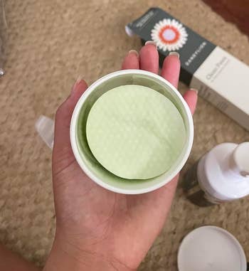 A reviewer holding the container of wipes showing the wipes inside