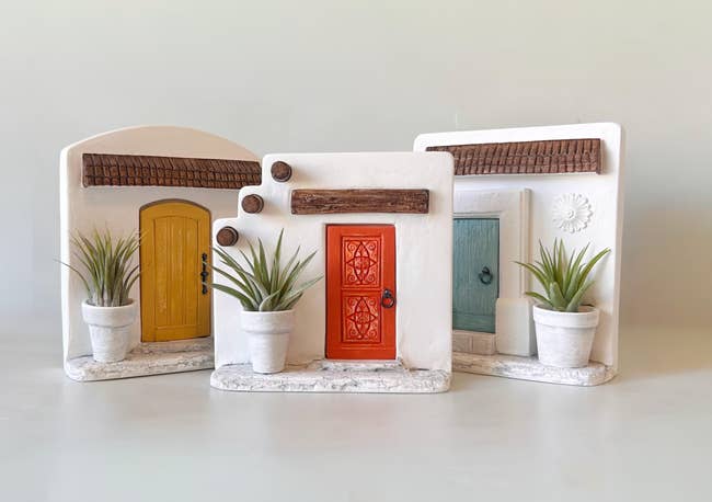 three spanish-style doorway  fronts with potted aerial  plants