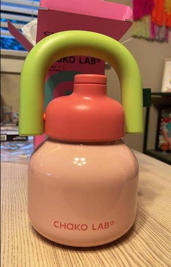 color artifact tiny h2o vessel with a grip and pinkish and greenish detailing