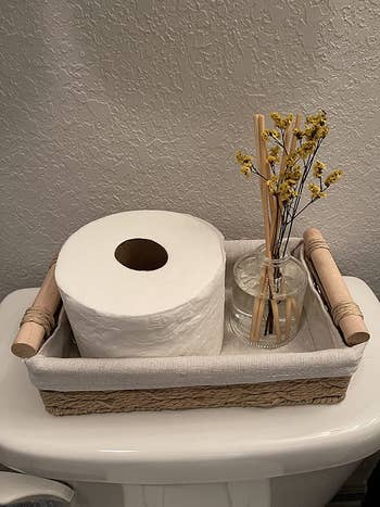 reviewer photo of toilet paper and incense in storage basket