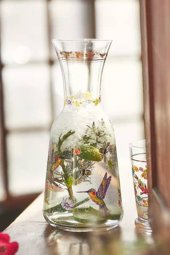 Glass pitcher with painted bird and floral design