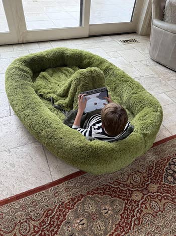 Child successful  ample  plush canine  furniture  playing connected  a tablet successful  a cozy surviving  room