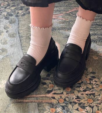 writer's black loafers with thick soles and white ribbed socks