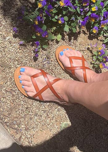 reviewer wearing the brownish sandals outside