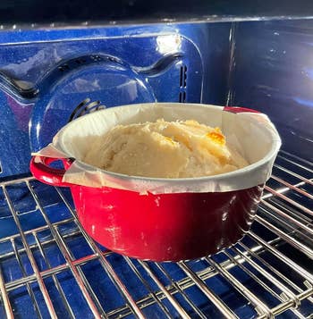 the reddish dutch oven successful the oven baking bread