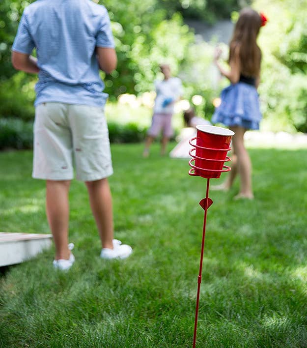 A red stake in the ground holding a red plastic cup