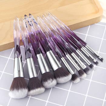 a set of makeup brushes with purple ombre crystal-liked handles