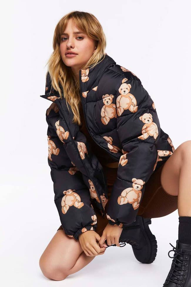 reviewer in black puffer jacket printed with teddy bears