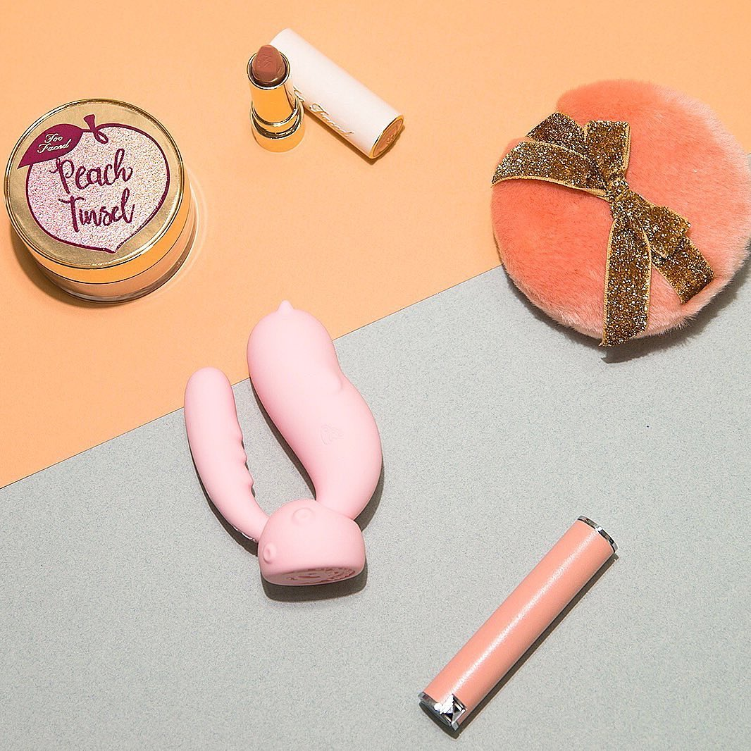 Pink vibrator and charging base surrounded by pink accessories
