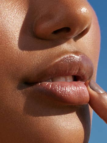a model applying lip balm to their lips