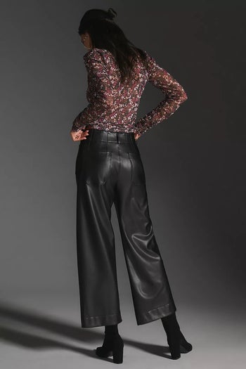 back of model wearing the black pants with a floral-print blouse