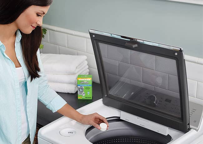 person putting tablet in washing machine