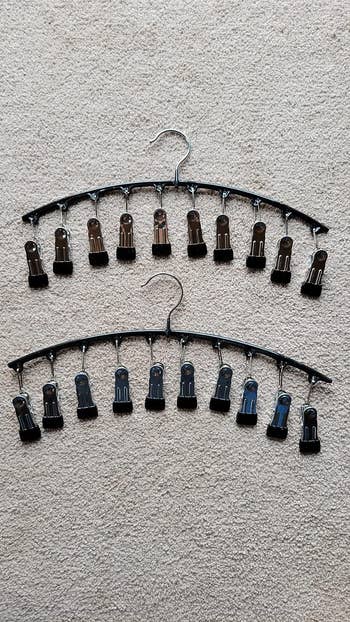 reviewer photo of two curved hangers with 10 clips on them to hold a 10 pairs of leggings
