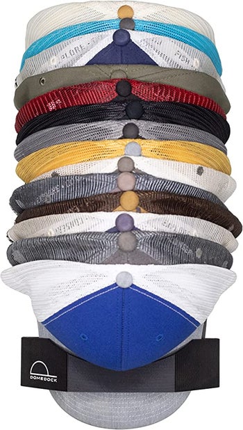 ball cap organizer mounted on wall with several hats inside