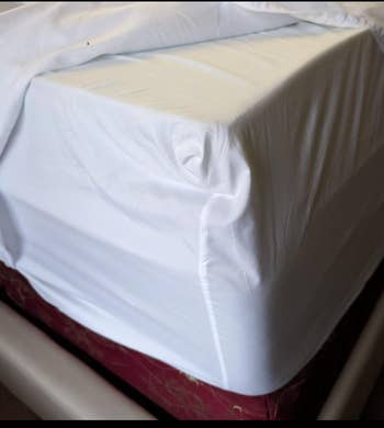 A white fitted sheet covers a mattress 
