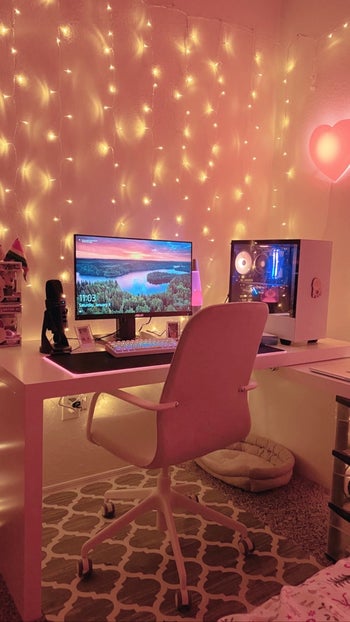 the fairy lights strung behind a pink desk setup