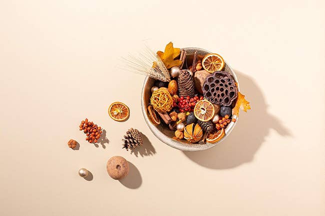 bowl of harvest potpourri with orange slices and other dried and preserved natural items 