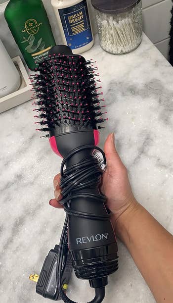 Reviewer holding the dryer brush