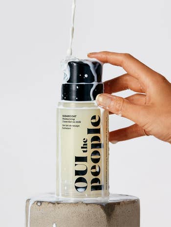 Milk being poured onto a bottle of Youth to the People skincare product placed on a pedestal