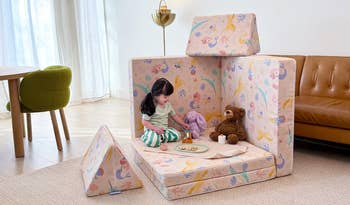 Child plays successful  a cushioned play   operation   with patterned fabric, surrounded by stuffed animals and toys, successful  a cozy country   setting