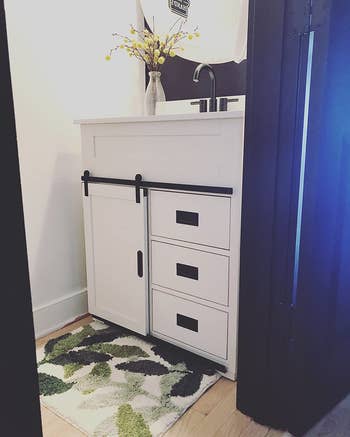 reviewer image of the rug in front of a bathroom vanity