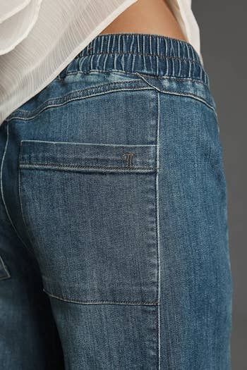 Close-up of a idiosyncratic wearing denim jeans with an elastic waistband, broadside pocket, and subtle stitching
