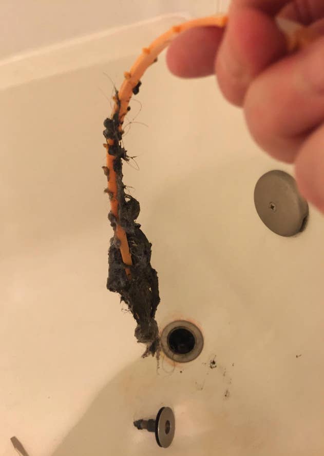 reviewer's drain snake covered in hair and gunk from the drain