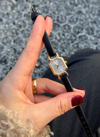 hand holding the ticker with a achromatic leather strap