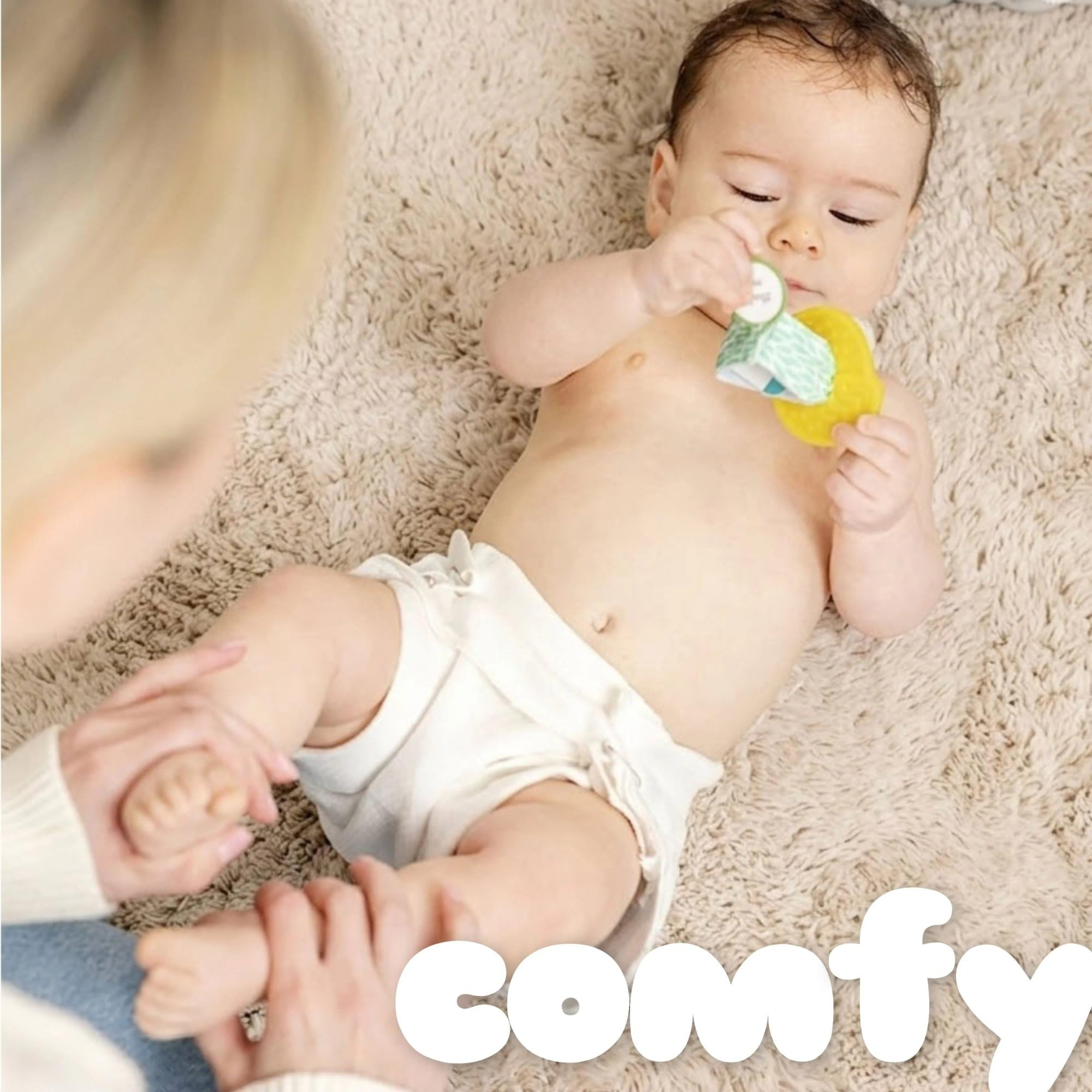 Baby successful  a diaper plays with a artifact  connected  a brushed  rug, with an big  mildly  holding their leg. Large substance   reads 