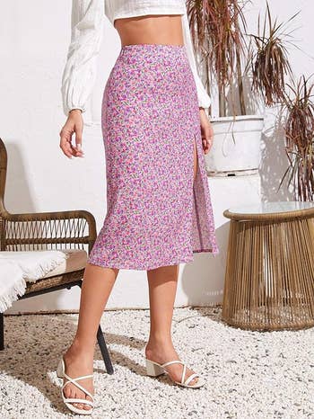 Person standing in a floral skirt and white heeled sandals