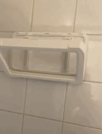 a reviewer rotating the shower phone holder