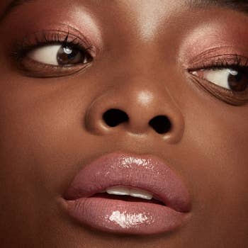 Close-up of a model's lower face highlighting glossy lips