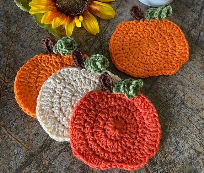 the four pumpkin coasters in orange, white, and red
