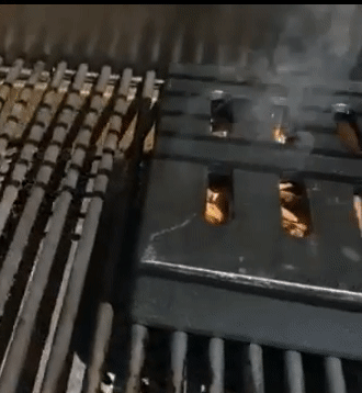 reviewer gif of the smoker box smoking on a grill