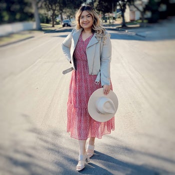 another reviewer wearing the pink and white dress with a gray leather jacket and white heels