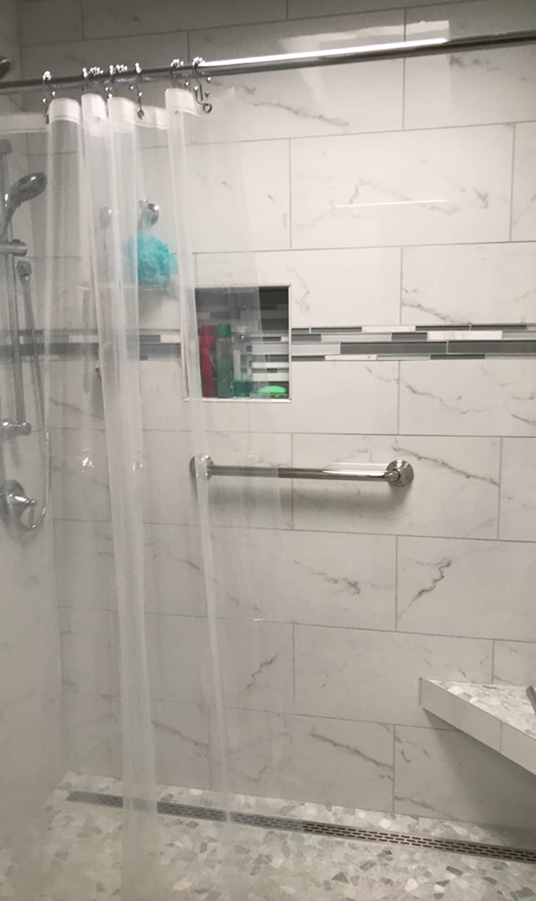 a clear shower curtain hung on a rod in a shower 