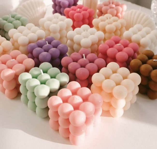 several bubble candles in various colors, including light green, pink, purple, and cream