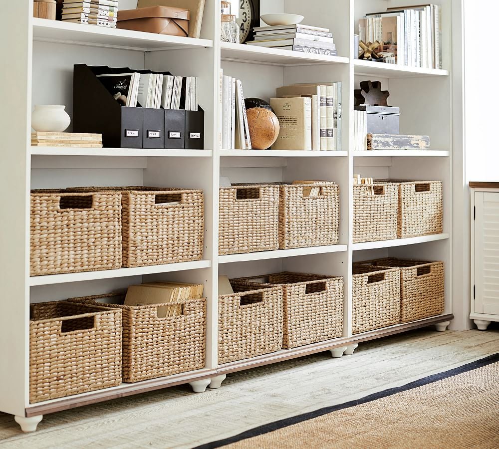 Woven baskets placed in white bookshelf