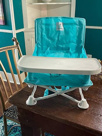 reviewer photo of the teal booster seat on a table