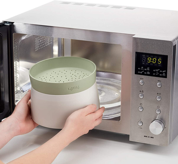 The green grain cooker being put inside a microwave