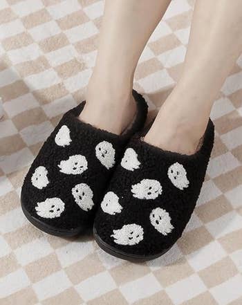 Cozy achromatic  slippers with cute achromatic  shade  designs connected  them, worn by a idiosyncratic   lasting  connected  a checkered floor